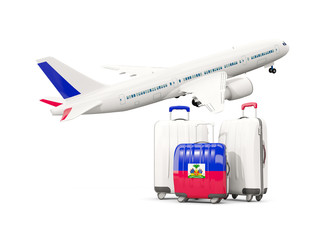 Luggage with flag of haiti. Three bags with airplane