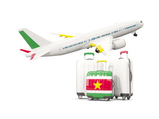 Luggage with flag of suriname. Three bags with airplane