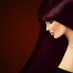 Healthy Hair and Hair Coloring Concept. Beautiful Woman with Long Red Hair on Background