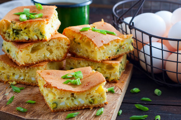 Cut into square pieces of pie with onions and eggs, horizontal