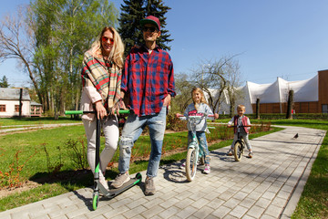 Fototapeta premium Couple with children on scooters
