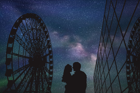 Lovers in amusement park at night. Vector illustration with silhouette of loving couple under starry sky. Ferris wheel and glass building