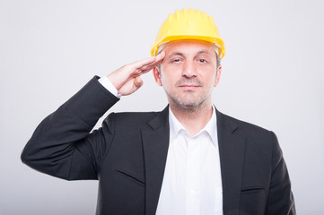 Portrait of foreman holding his hardhat making salute gesture