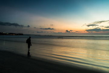 Beautiful sunset of Kuta Beach, Bali, Indonesia. Silhouettes of people at sunset on Kuta beach in Bali, Indonesia