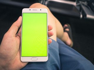 A man holding smartphone with green keyed out screen