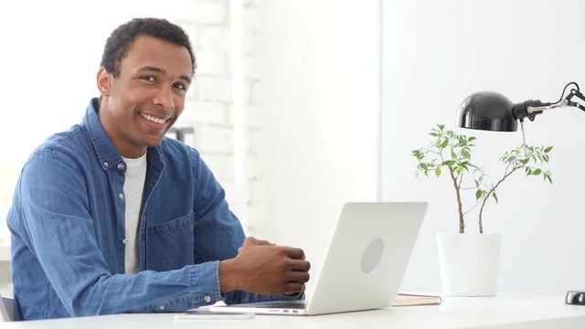 Afro-American Man at Work Smiling  toward Camera