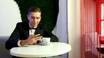Young man using smartphone in a cafe