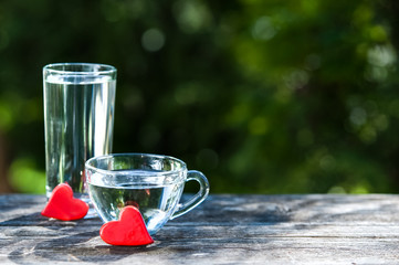 Two bowls with water and red hearts, as a symbol of love of water and all life.. Clean water, health, food industry, health, Ecology, environmental protection, thirst quenching