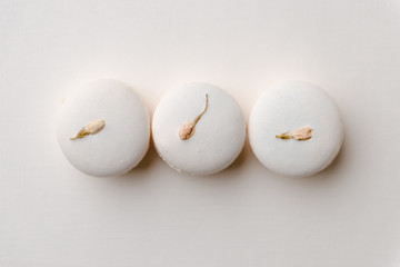 Sweet white macaroons on white table background.