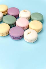 Sweet colorful macaroons on blue table background.