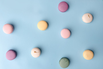 Sweet colorful macaroons on blue table background.