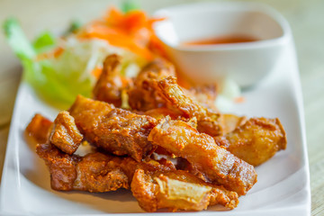 Sun dried pork fried on white dish with chilli sauce in restaurant