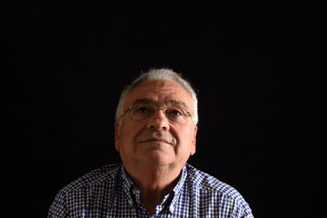 Portrait of a senior man with black background