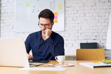 Fototapeta premium Thoughtful web designer, artist working at creative agency office