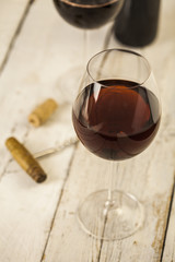 Wine glass and bottle on a wooden table with bricks wall background