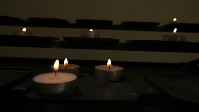 Camera Pans From Right To Left Over Lit Candles On An Altar At The Oude Kerk (Old Chruch) In Amsterdam, Netherlands