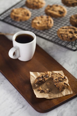 Coffee cup and Cookies on a cooling rack over a marble table