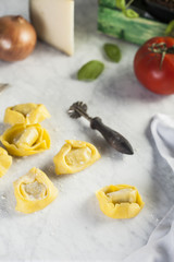 Raw and fresh big tortellini in a marble table