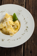 Plate of big tortellini in a wooden table