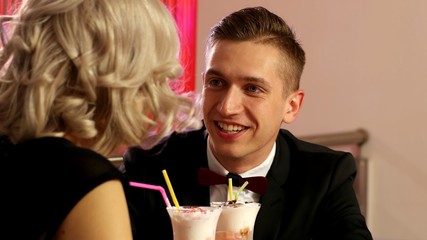 Young guy in a black jacket on a date in the Café