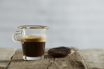 Delicious coffee cup with chocolate biscuit on wooden background