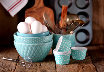 Organic chicken eggs and kitchen accessories for making cupcakes. Rustic style. Wooden background.