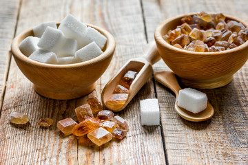 Fototapeta premium variety lumps of sugar in bowls on wooden table background