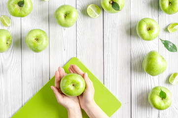Fototapeta na wymiar fitness food with green apples in hand on white background top view