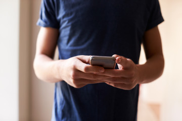 Close Up Of Young Man Sending Text Message On Mobile Phone