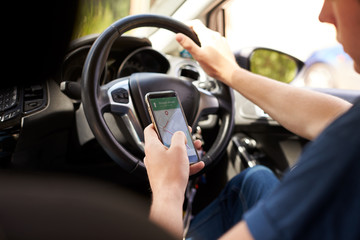 Young Man Using Satellite Navigation on Phone Whilst Driving