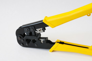 Crimping tool with yellow handles on white background. Crimping pliers closeup