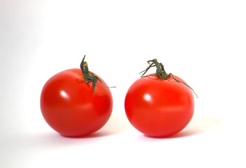 Two ripe red small tomatoes on a white background