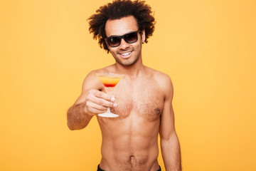 Young smiling african man holding cocktail.