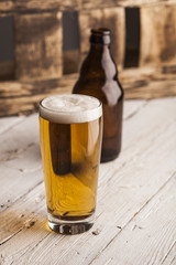 Bottle and glass of beer with wooden background