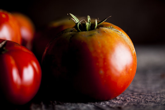 Natural and organic tomatoes on a dark wooden background