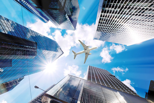 Airplane flying over business skyscrapers