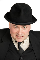 An elderly man in a black hat is very angry