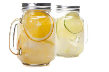 Lemonade in a mason jar with fruit slices isolated on white