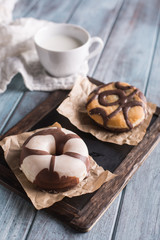 Chocolate donuts on a blue wooden table and a cup of milk