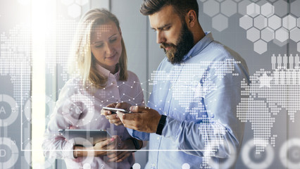 Businessman showing business women information on smartphone screen. Woman holding digital tablet