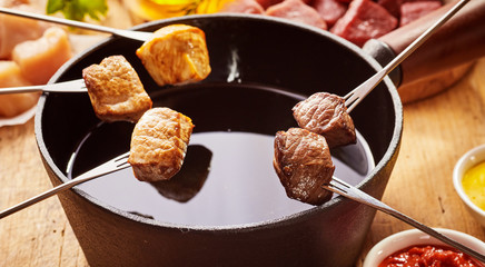 Cubes of cooked meat over pot of oil