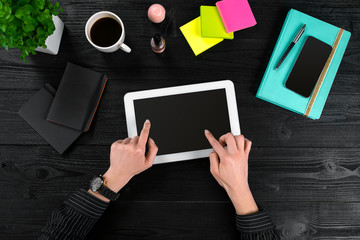 Mix of office supplies and gadgets on a wooden desk background. View from above.