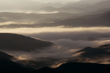 Mountain landscape at dawn with fog and tonal perspective.