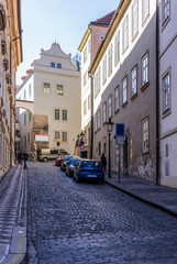 Quiet and cozy street of cobbled stone pavement . Old lanterns and constructive arches. The nineteenth century.  The Old Town District . Prague , Czech Republic.