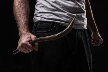 Male offender with a scrap. On black background at the studio