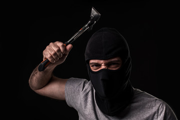 Criminal in T-shirt and balaclava with hammer