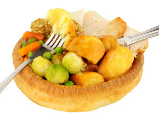 Roast chicken dinner in a large Yorkshire pudding isolated on a white background