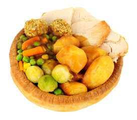 Roast chicken dinner in a large Yorkshire pudding isolated on a white background