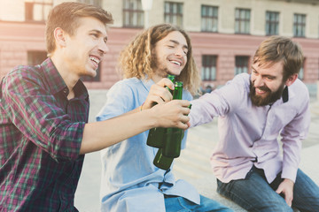 Happy friends cheers with beer outdoor