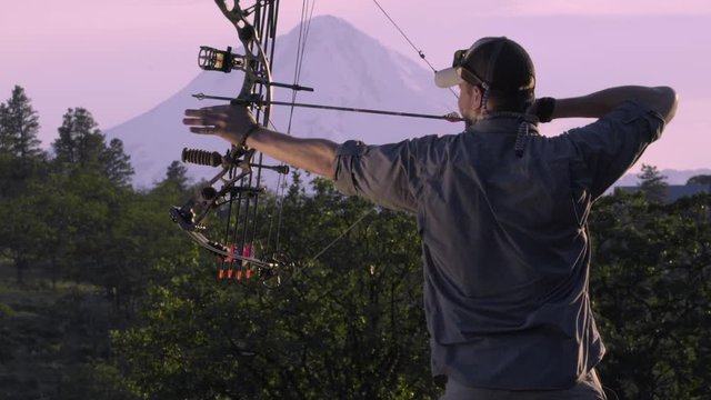Hunter Draws Backs His Compound Bow And Releases His Arrow (Slow Motion)